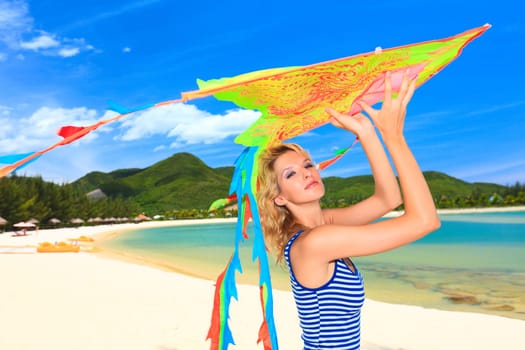Young woman with kite on the beach