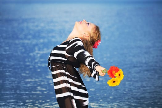 Beautiful woman with flowers in the sea