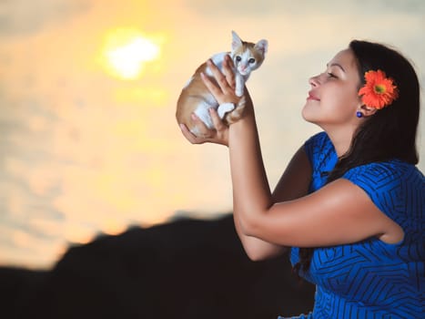 Woman with kitten outdoor at sunrise time