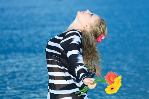 Beautiful woman with flowers in the sea