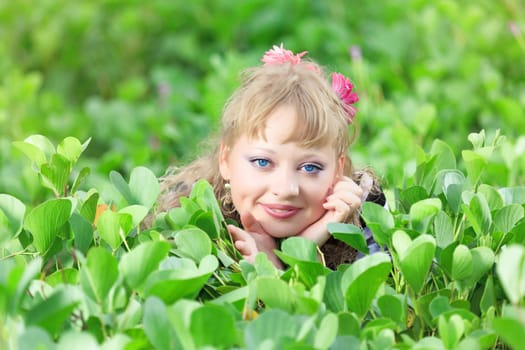 Beautiful woman in grass with gerbera flowers