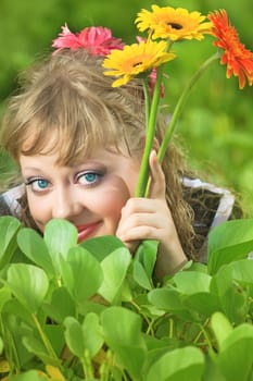 Beautiful woman in grass with gerbera flowers