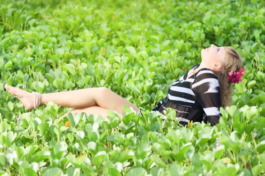 Beautiful woman in grass with gerbera flowers