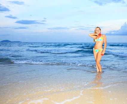 Beautiful young woman with flower at the beach