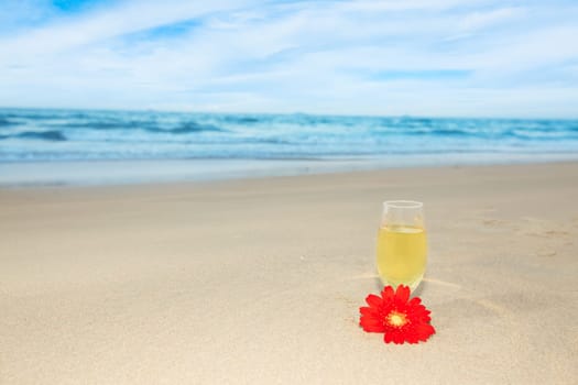 Glass of white wine on the beach