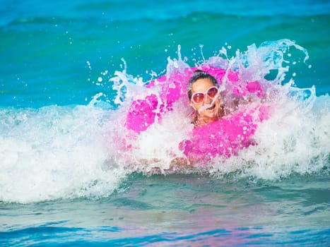 Woman swimming on innertube on the waves