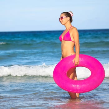 Woman with inner tube on the tropical beach