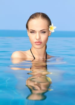 Cute blond girl relaxing in swimming pool