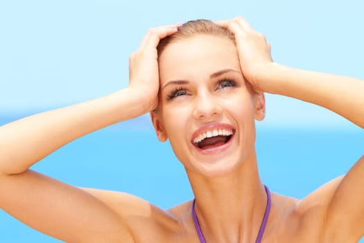 Happy young woman smiling while on the beach in her bikini