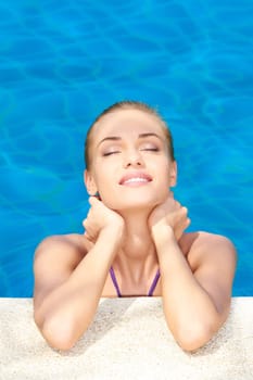 Dreaming woman with eyes closed in swimming pool