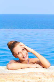 Close up of cute girl in infinity pool with copy space