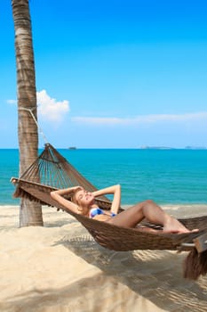 Woman tourist on a summer vacation enjoying the serenity of a tropical beach at a waterfront retreat