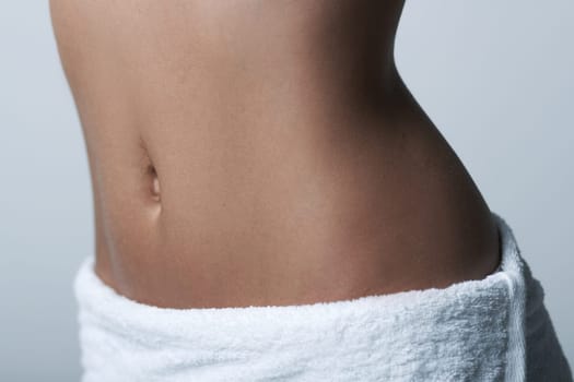 Beautiful womans body part wearing white towel on clear background