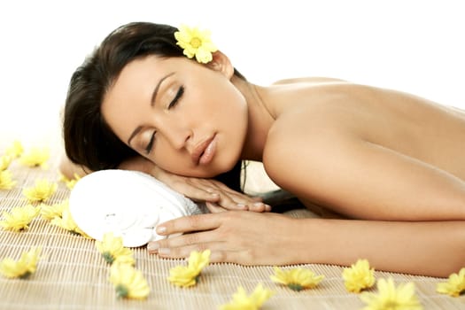 Portrait of Fresh and Beautiful brunette woman laying on bamboo mat around yellow flowers