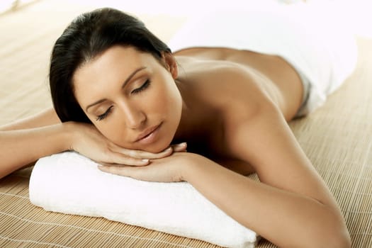 Portrait of Fresh and Beautiful brunette woman laying on bamboo mat