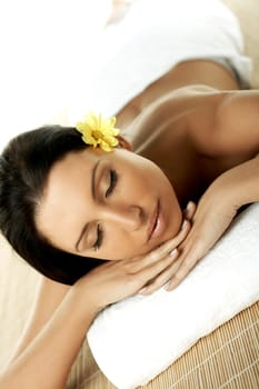 Portrait of Fresh and Beautiful brunette woman laying on bamboo mat around yellow flowers