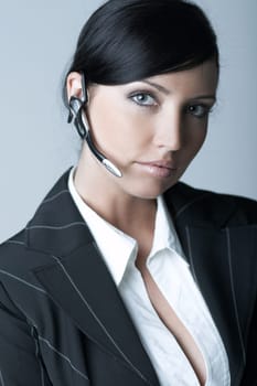 Beautiful brunette business woman with wireless headset isolated on clear background