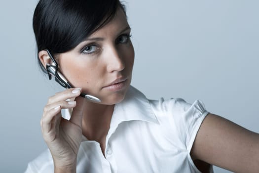 Beautiful and sexy brunette business woman talking telephone. She is isolated on clear background