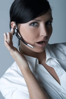 Beautiful brunette business woman with wireless headset isolated on clear background