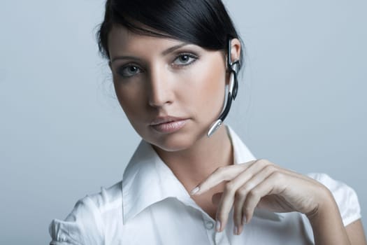 Beautiful brunette business woman with wireless headset isolated on clear background