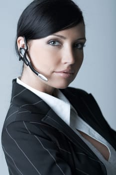 Beautiful brunette business woman with wireless headset isolated on clear background
