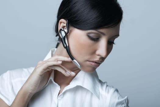 Beautiful brunette business woman with wireless headset isolated on clear background