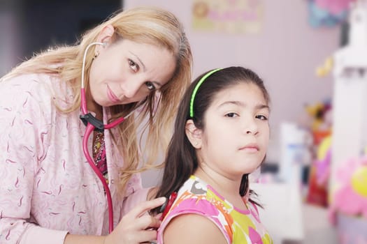 Pediatrician examining little girl with stethoscope