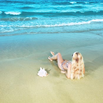 Young woman in bikini near the water