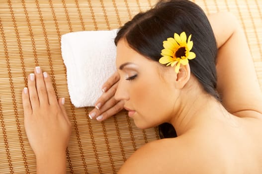 Portrait of Fresh and Beautiful brunette woman laying on bamboo mat