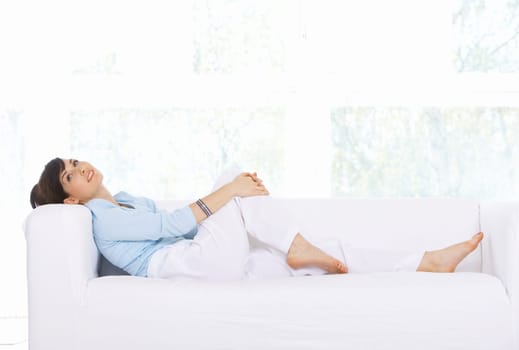 Young woman relaxing on couch in her home