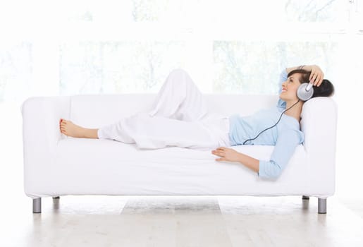 Young woman on couch and listen to the music