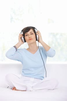 Young woman on couch and listen to the music