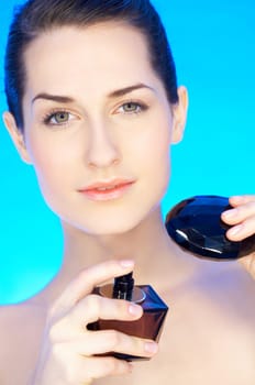 Portrait of 20-25 years old beautiful woman with bottle of perfume