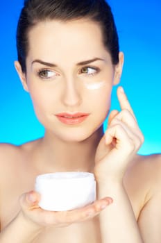 Portrait of beautiful woman holding cream