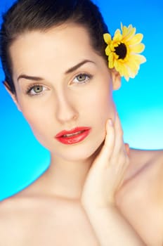 Portrait of beautiful woman with sunflower in hair