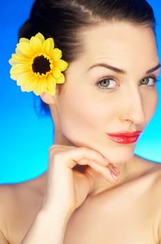 Portrait of beautiful woman with sunflower in hair
