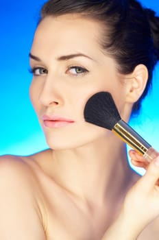 Portrait of beautiful woman with cosmetics brush