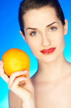 Portrait of beautiful woman with orange fruit