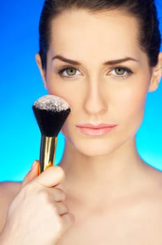 Portrait of beautiful woman with cosmetics brush
