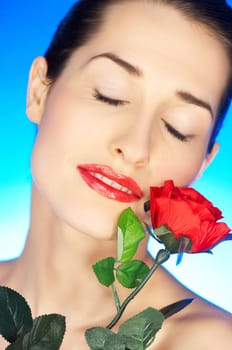 Portrait of beautiful woman with red rose