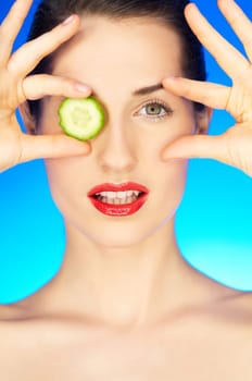 Portrait of beautiful woman with cucumber slice