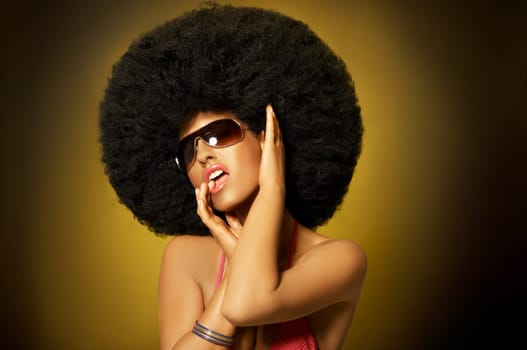 Beautiful woman with huge afro haircut on yellow