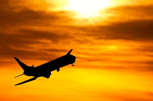 silhouette of an airplane taking off at sunset