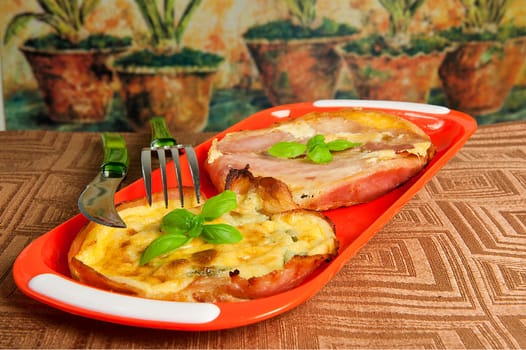 Eggs and bacon tart with basil leaves