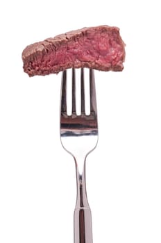 Roasted piece of beef tenderloin on a fork is white isolated