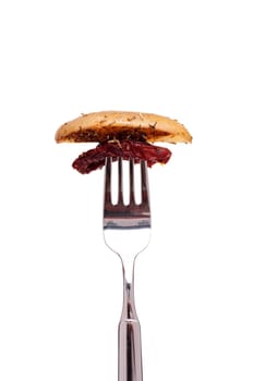 Fried potato and dried tomato on a fork