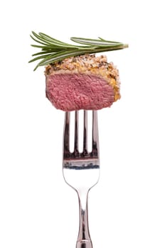 White isolated saddle of lamb with bread crust and rosemary on a fork