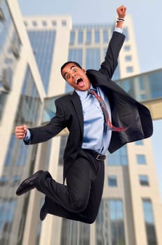 Happy businessman jumping outdoors