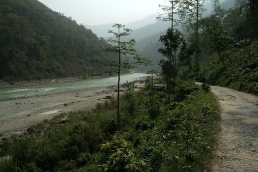 Road running parallel to river in mountain valley