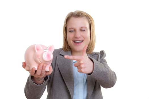 Young woman pointing at piggy bank in her hand